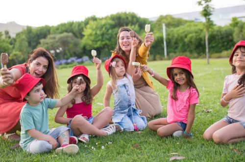 A joyful family enjoying ice cream on a sunny day in a Portuguese park.